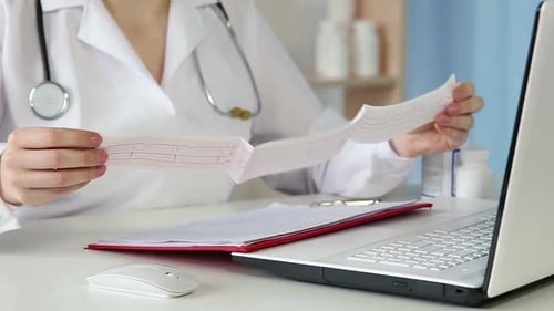 Cardiologist Reading Electrocardiogram, Analyzing Symptoms to Make a Diagnosis