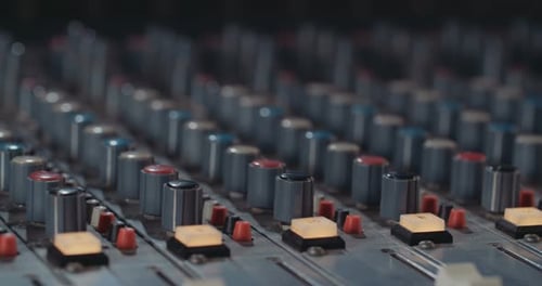 Sound engineer working in a recording studio with a sound console and microphones