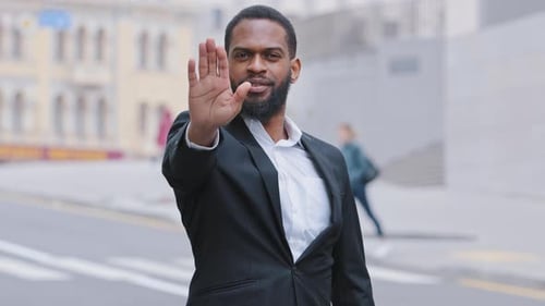 Man in Suit Gestures Stop in Urban Setting