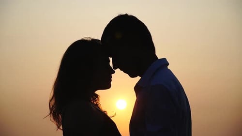 Romantic Couple Silhouette Against a Golden Sunset