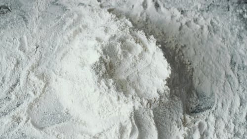 Egg Being Poured Into Flour Close Up