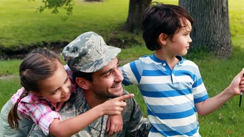 Soldier Father Embraces Children with American Flag