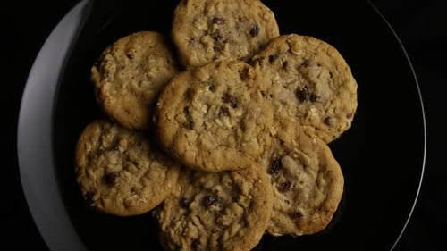 Oatmeal Raisin Cookies Piled on a Black Plate