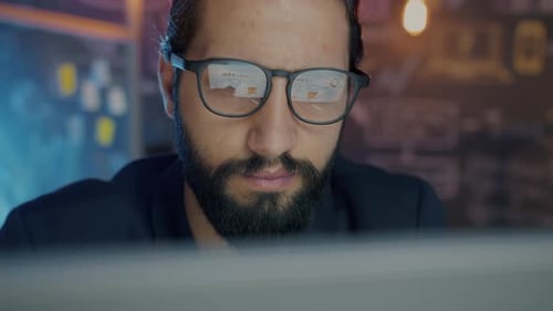 Closeup of Young Businessman Working with Laptop in Office in the Evening