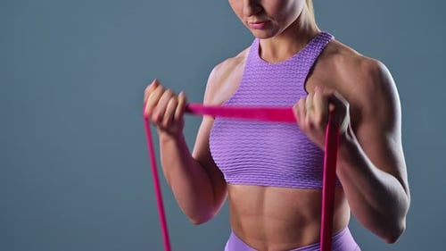 Muscular Woman Works Out with Resistance Band