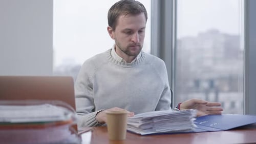 Middle Shot of Busy Overworked Man Putting Away Folder As Unrecognizable Woman Bringing More Job