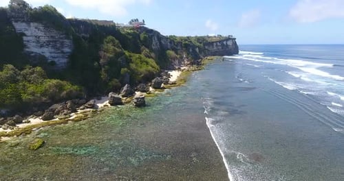 Stunning Aerial View of Azure Ocean and Waves Crashing at Rocky Cliffs with Splashing and White Foam