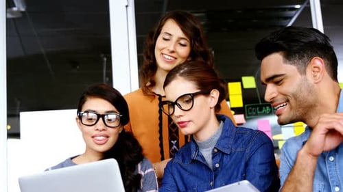Smiling Colleagues Collaborating on Project at Workplace