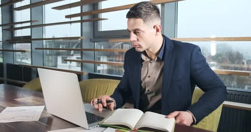 Besorgter Mann arbeitet am Laptop und schaut weg und denkt daran, Probleme im Büro zu lösen