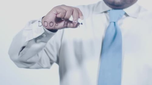 Man Writing DDOS Attack on Clear Surface