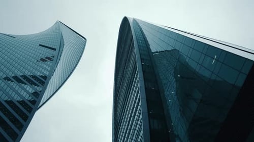 Panoramablick auf moderne Wolkenkratzer aus Glas. Kamerabewegung von unten nach oben, Drehung