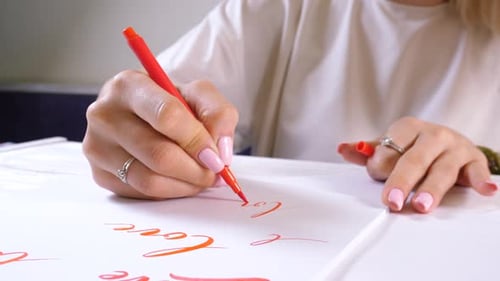 Woman Writes Love in Cursive with Red Pen
