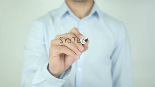Man Writing the Word System with Marker