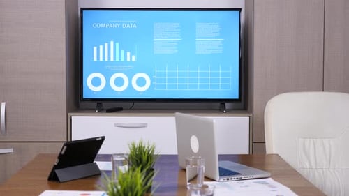 Close Up of Empty Business Meeting Room with Big TV and Animated Data