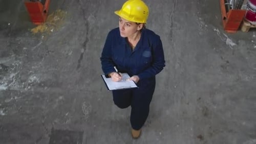 Female Inspector Walking through Warehouse