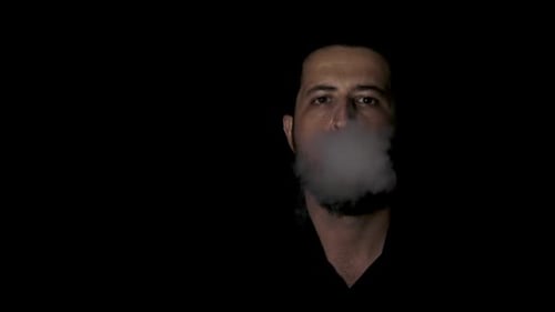 Man Exhaling Vapor in the Dark