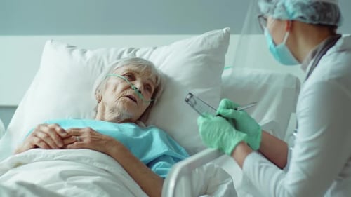 Elderly Woman in Hospital Bed with Oxygen Support