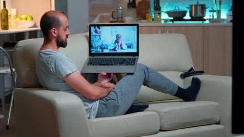 Man on Couch Having Telehealth Appointment