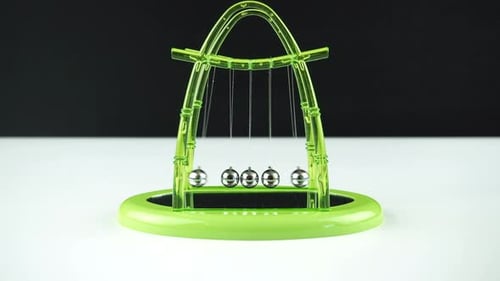 Newton's Cradle with Green Plastic Frame Demonstrating Physics