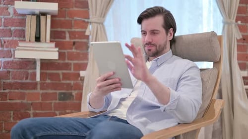 Man Using Tablet in Rocking Chair Indoors