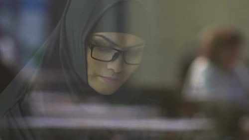Intelligente muslimische Frau mit Brille, Lesebuch, Vorbereitung auf Aufnahmeprüfungen