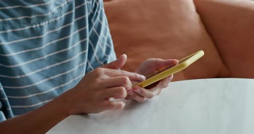 Person Using Smartphone at Table Indoors