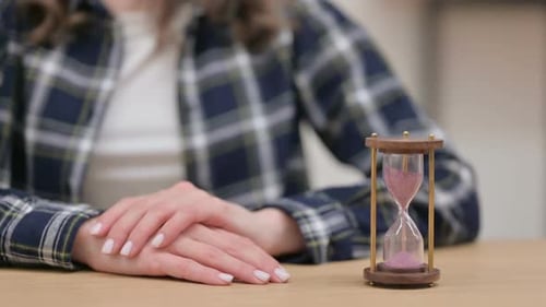 Hourglass Next to Female Hands Waiting Gesture Close Up