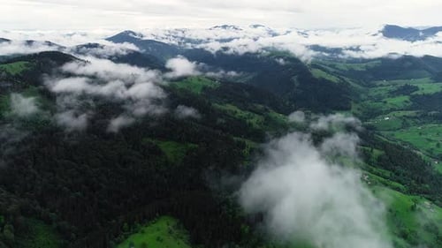 Flying Through the Clouds Above Mountain Tops. High Peaks with Forest, Wonderful Natural Landscape