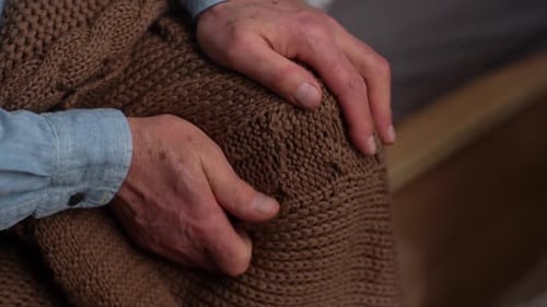 Close Up of Senior Adult Hands Resting on Knee