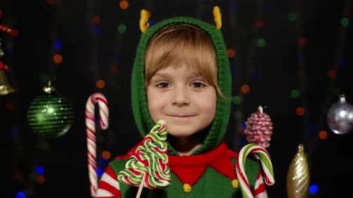 Happy Child Dressed as Elf Eating Candy