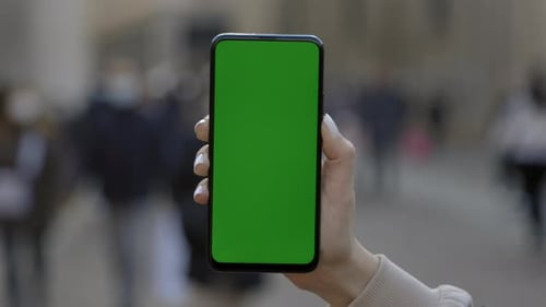 Woman at Street Using Smartphone with Green Mockup Screen Chroma Key