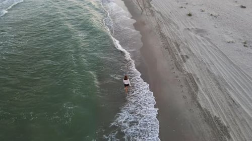 Beautiful Barefoot Woman Walking Along Deserted Beach