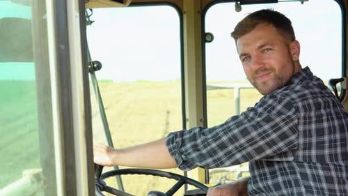 Smiling Farmer Driving Tractor on Sunny Day