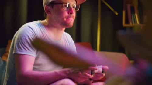 Young Adult Plays Video Games at Home at Night