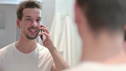 Young Man Chatting on Phone in Bathroom