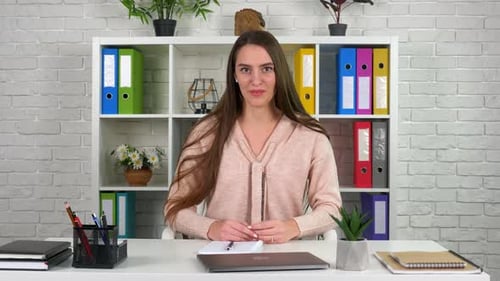 Young Woman Talking at Desk in Office