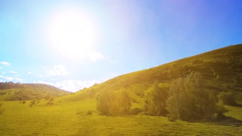 UHD Mountain Meadow Zeitraffer im Sommer. Bewegung von Wolken, Bäumen, grünem Gras und Sonnenstrahlen.
