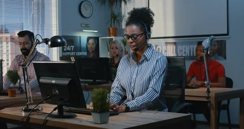 Frau hilft ihrer Kollegin in einem Support Center