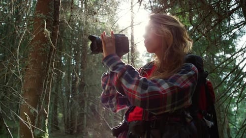 Woman Taking Photos on Camera in Forest