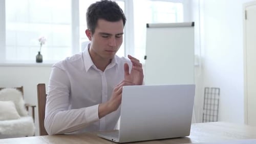 Man Working on Laptop with a Headache
