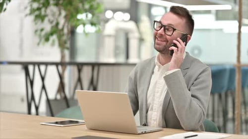 Man Talking on Phone at Office Desk