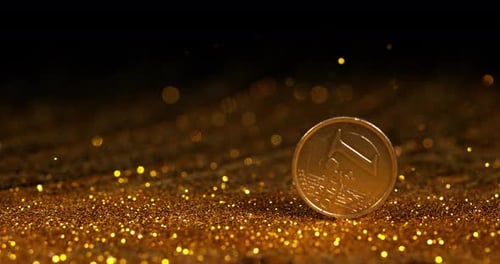 Münze von 1 Euro auf Goldpulver vor schwarzem Hintergrund, Zeitlupe 4K