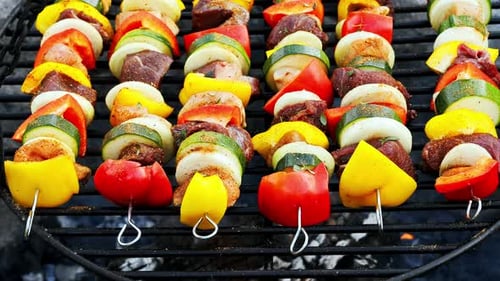 Homemade and spicy skewers on grill with meat and vegetables in summer