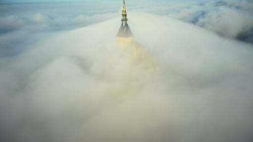Drone Is Slowly Flying Far Away From Epic Mont Saint Michel Castle Covered By Ethereal Fog Clouds in