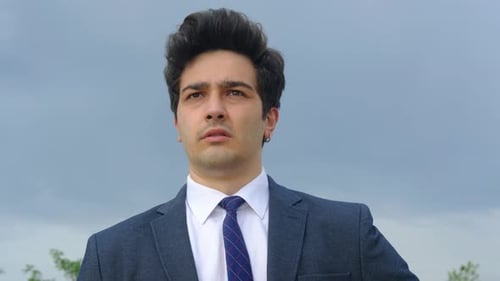 Young Man Putting on Sunglasses Wearing Suit