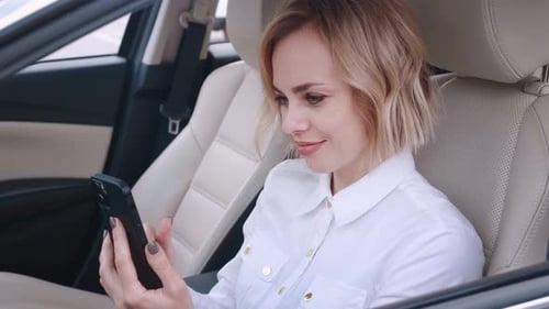 Woman Uses Smartphone in Car Interior
