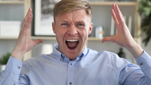 Blond Man Yelling in Frustration Indoors