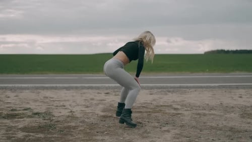 Hot Girl Is Dancing Outdoor at the Road Background. Sexy Blonde Woman Is Practicing Dance