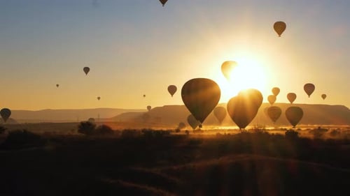 Hot Air Balloons at Sunrise over Rural Landscape