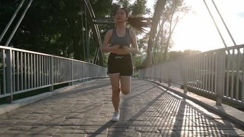 Young Asian Jogger Having a Morning Run Jogging Down the Track in Summer Park Healthy Way of Life